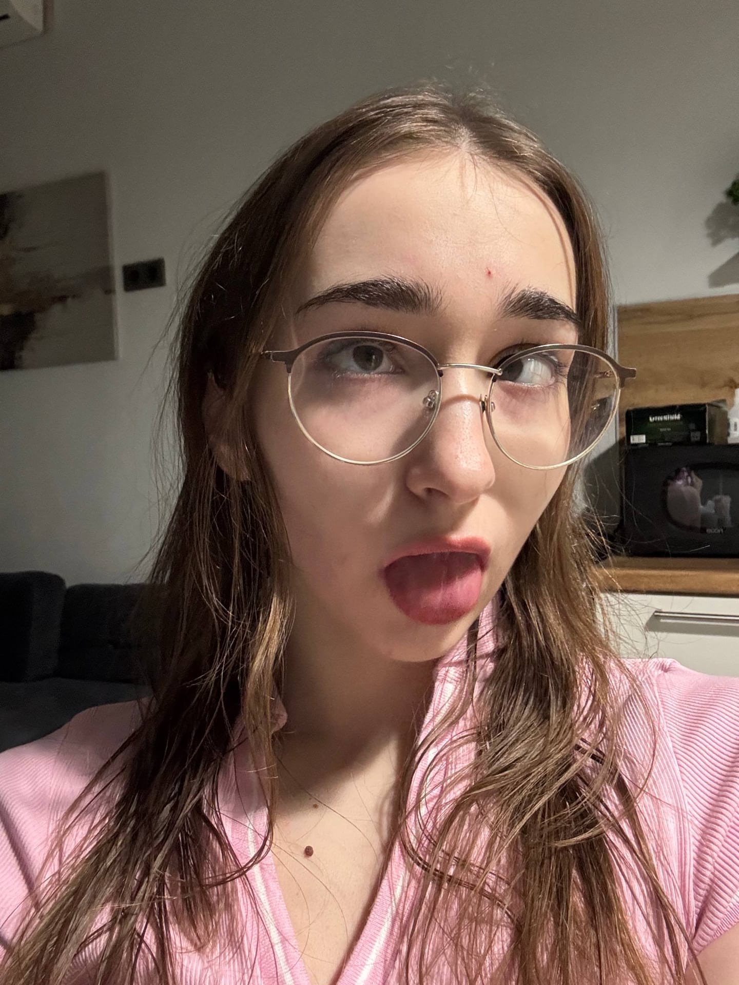 Amateur girl with glasses and long hair takes selfies in revealing outfits