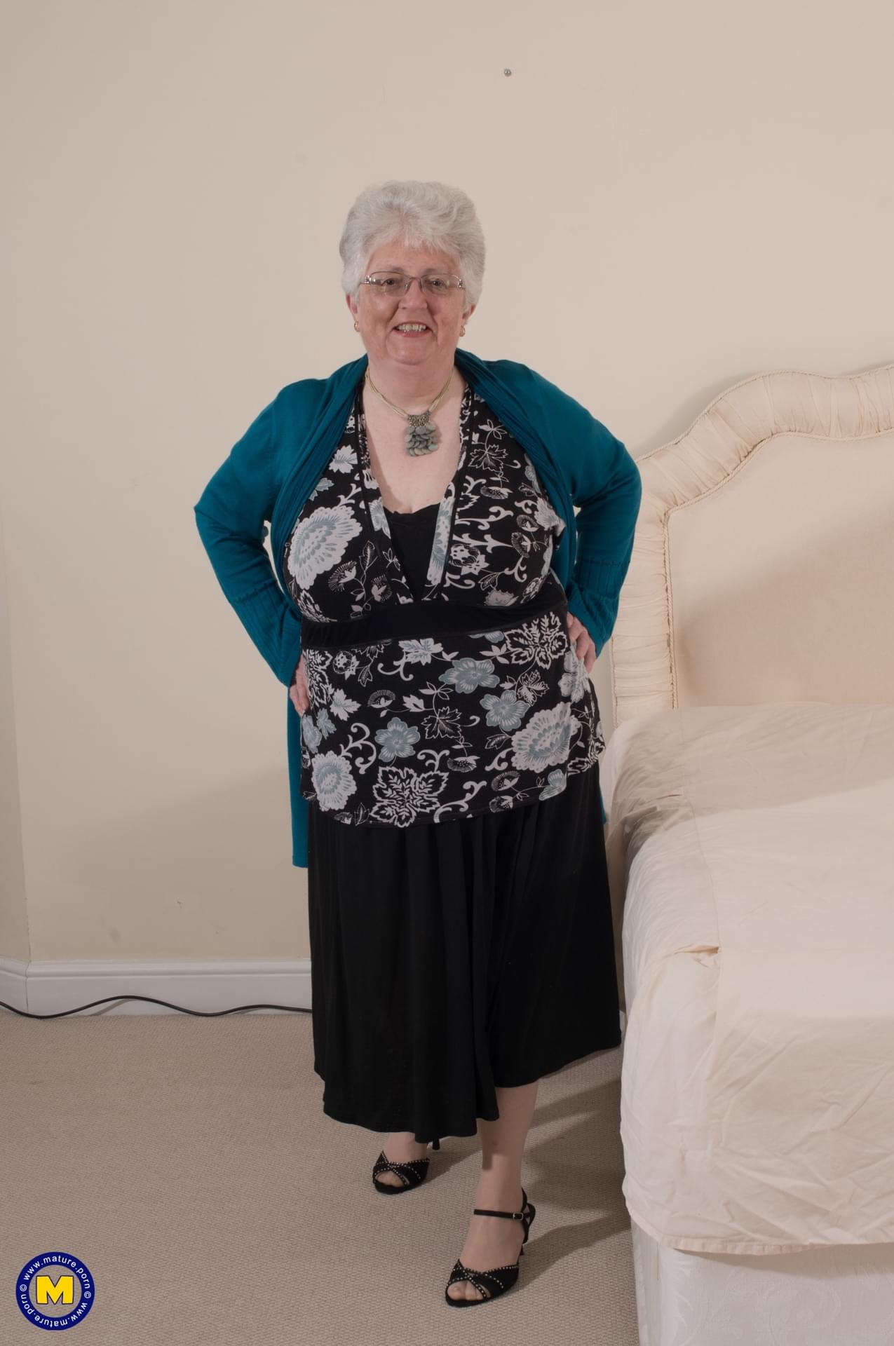 淫荡奶奶 Caroline V 在床上抚摸她的大乳房和玩弄她的肥逼