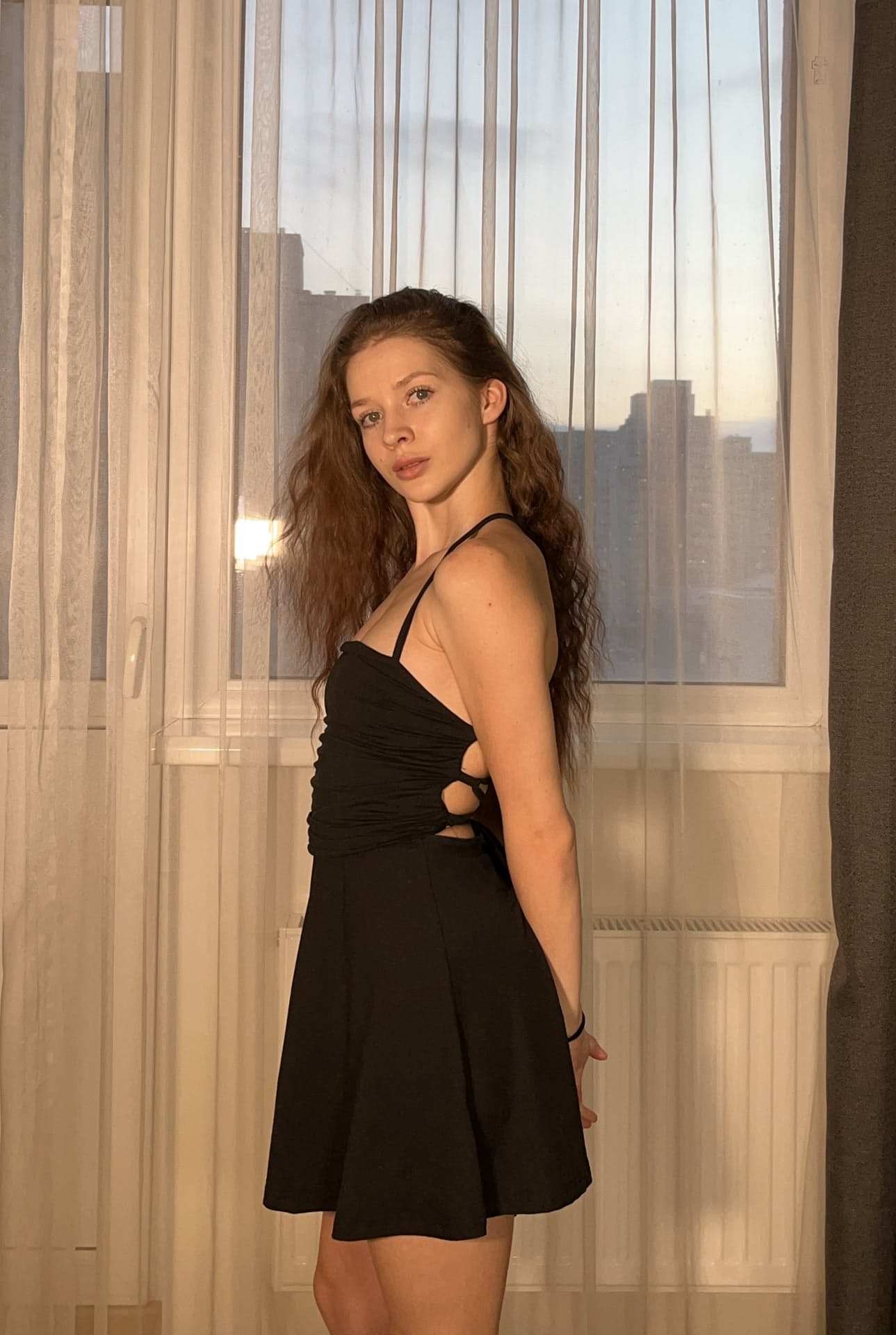 一位长发年轻美女身着黑色连衣裙，为个人写真摆出各种姿势
