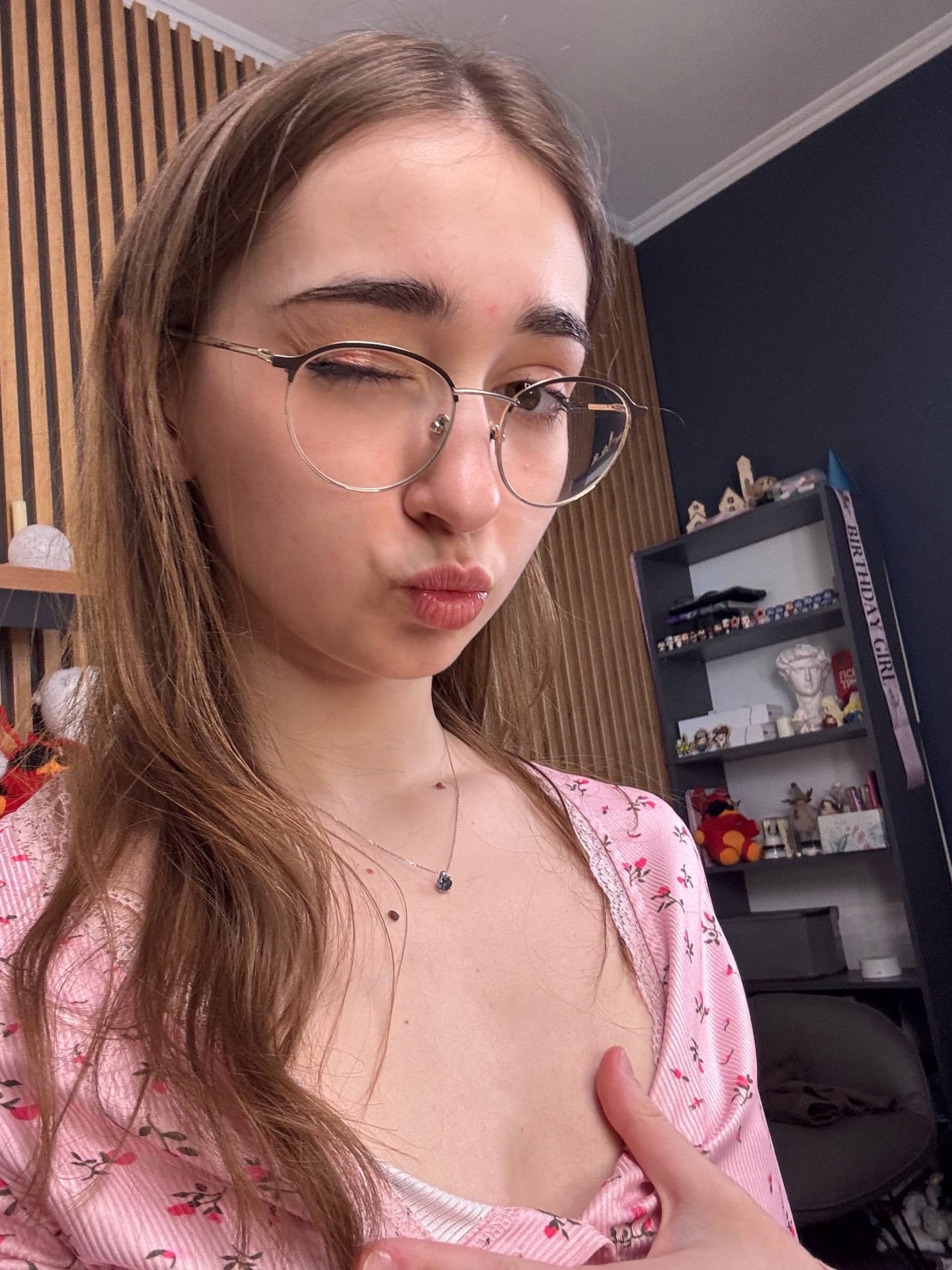 Thin teen with long hair takes selfies while wearing her glasses