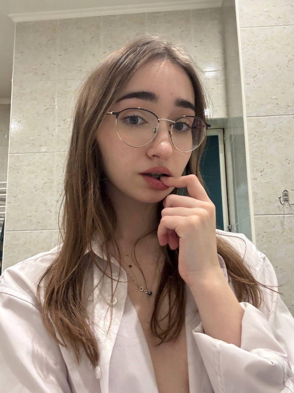 Amateur girl with glasses and long hair takes selfies in revealing outfits