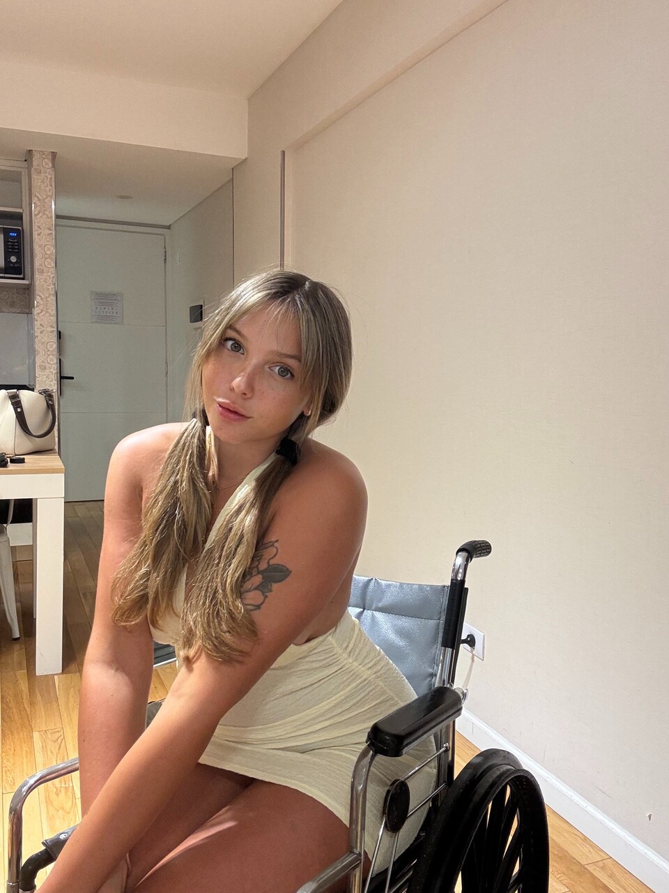 Young blonde removes a thong from her tight dress while in a wheelchair