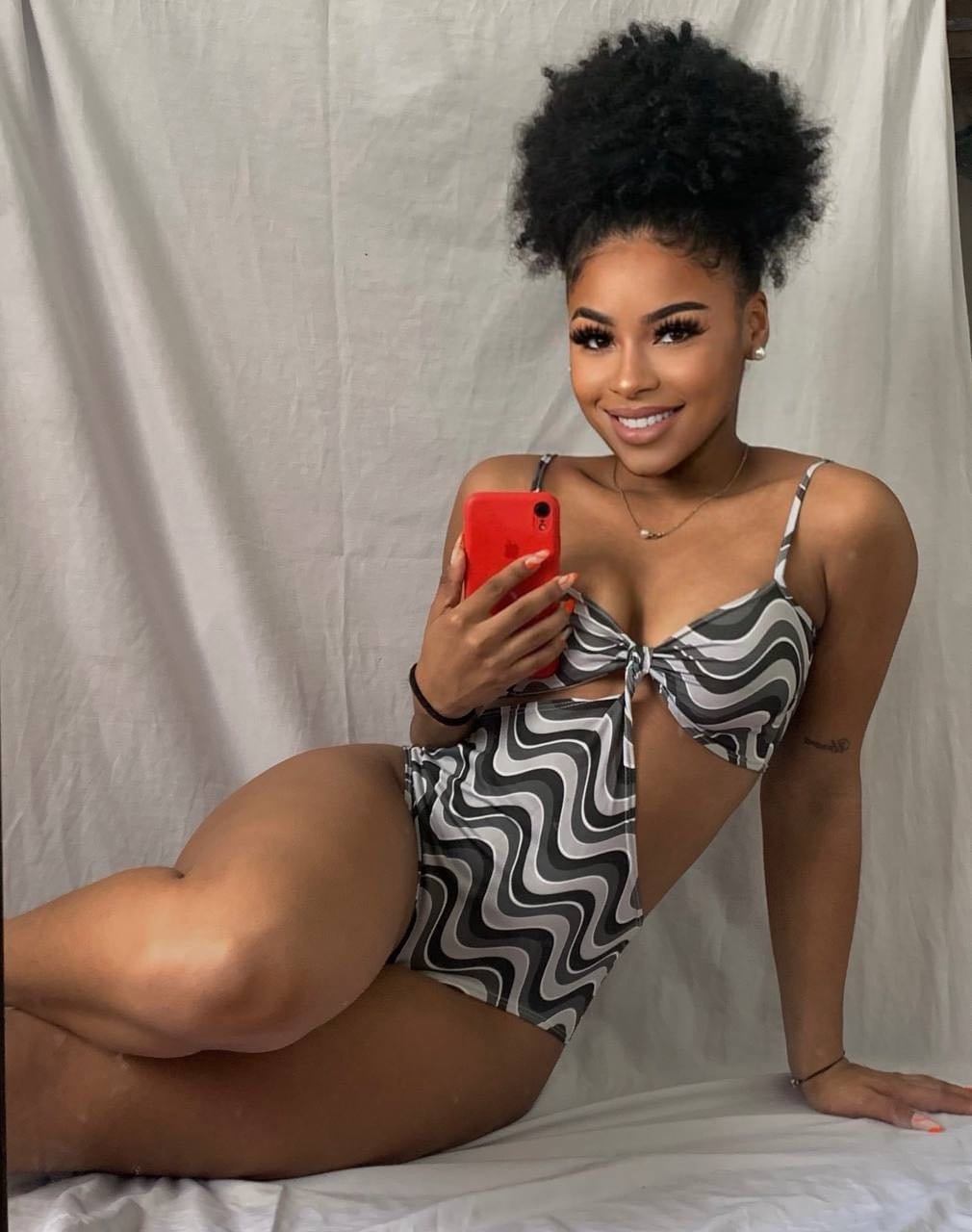 Ebony solo girl with a full head of curly hair models a lot of outfits