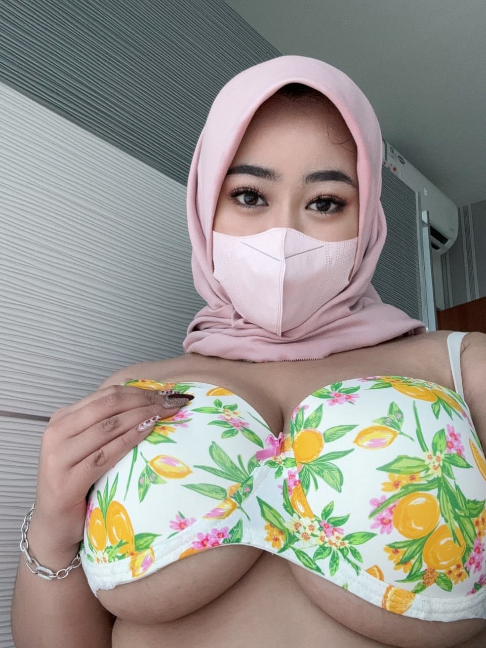 Solo girl with a mask over her mouth sports a hijab while exposing herself