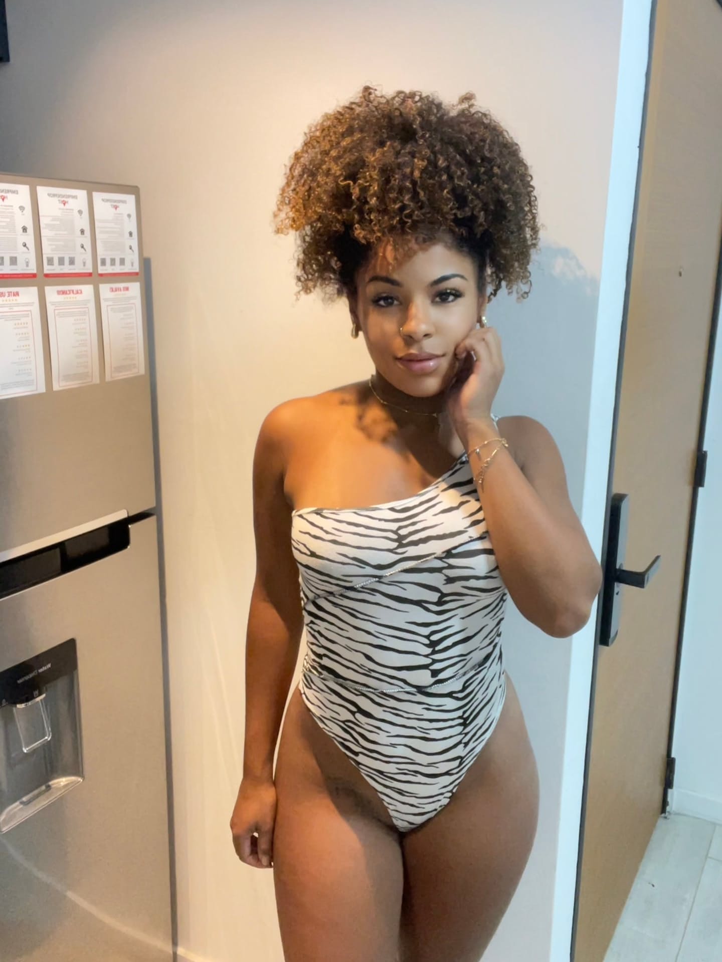 Ebony solo girl with a full head of curly hair models a lot of outfits