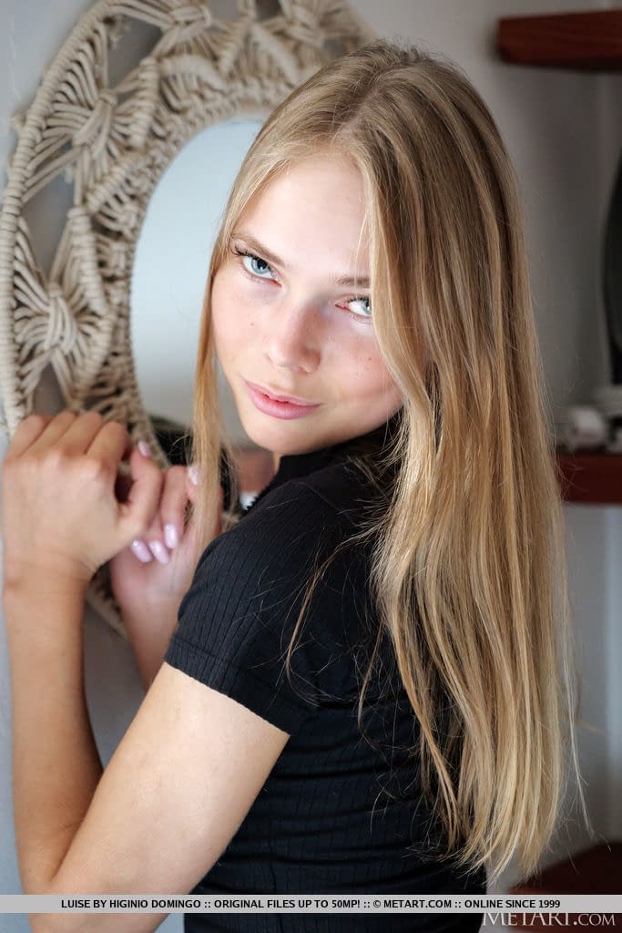Young blonde removes a black dress to model in the nude during solo action