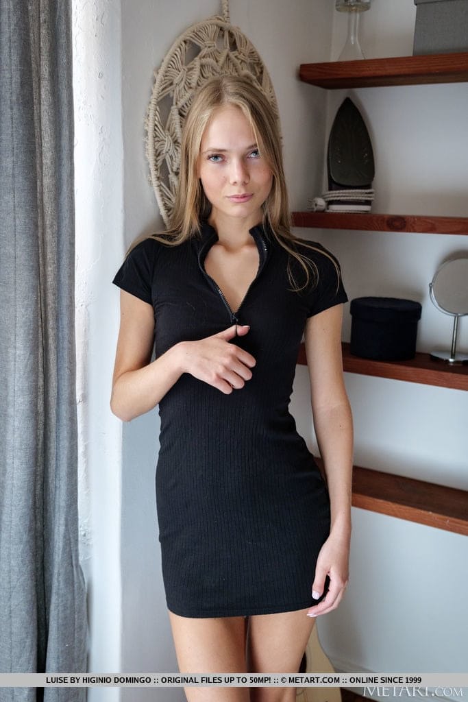 Young blonde removes a black dress to model in the nude during solo action