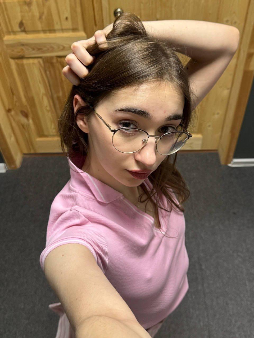 Amateur girl with glasses and long hair takes selfies in revealing outfits
