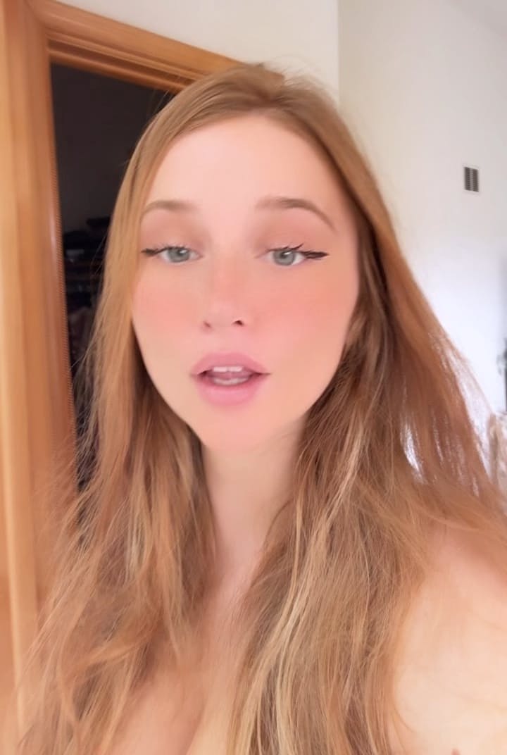 Young redhead takes selfies while exposing her tiny tits and pussy