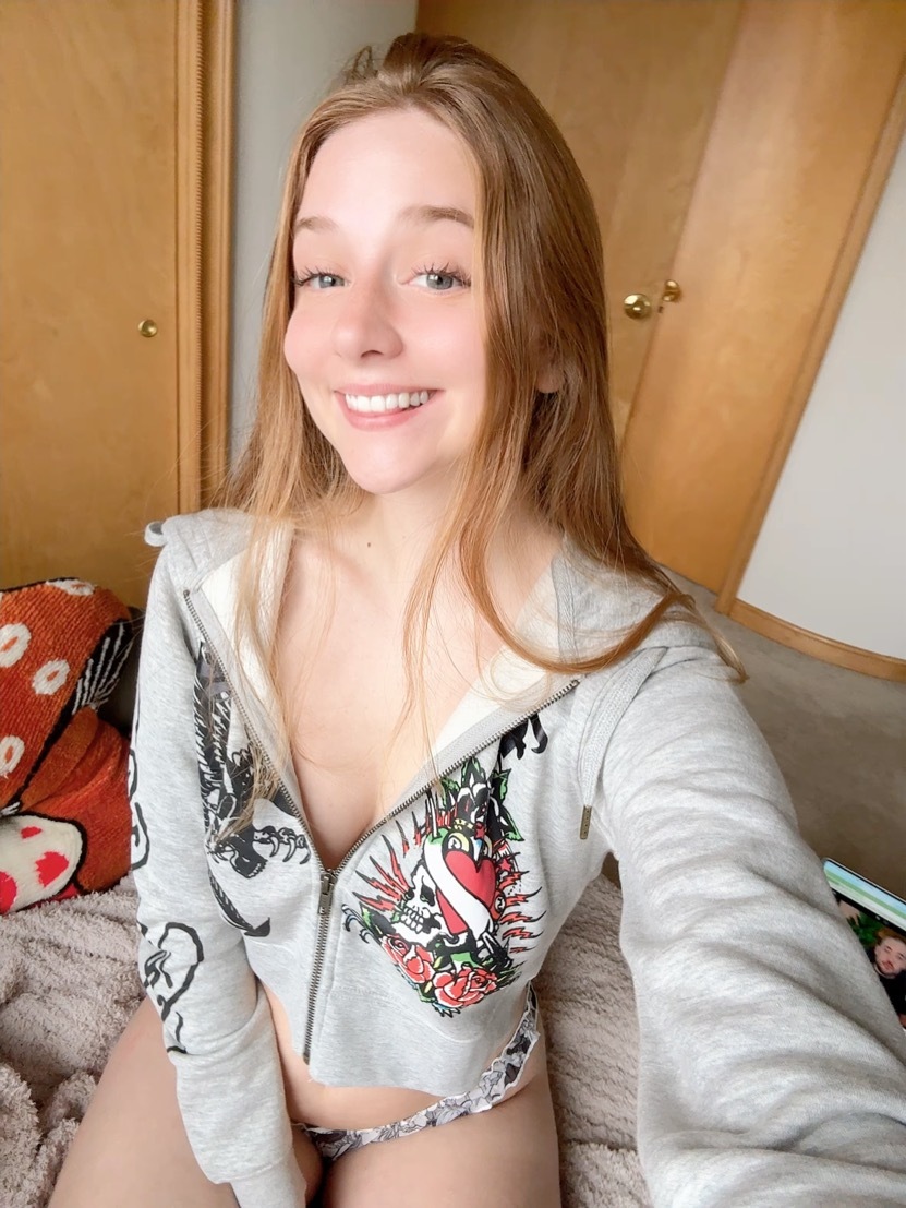 Young redhead takes selfies while exposing her tiny tits and pussy