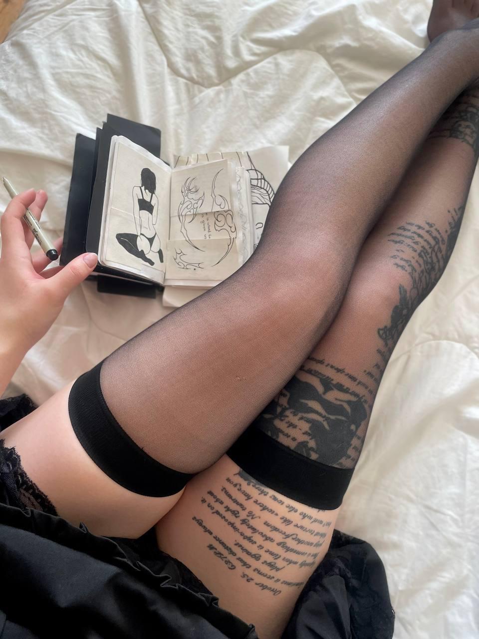Dark-haired girl takes selfies while wearing black stockings and a black dress