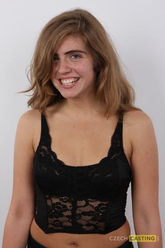 Flexible girl slips off her clothes and shoes in order to stand naked