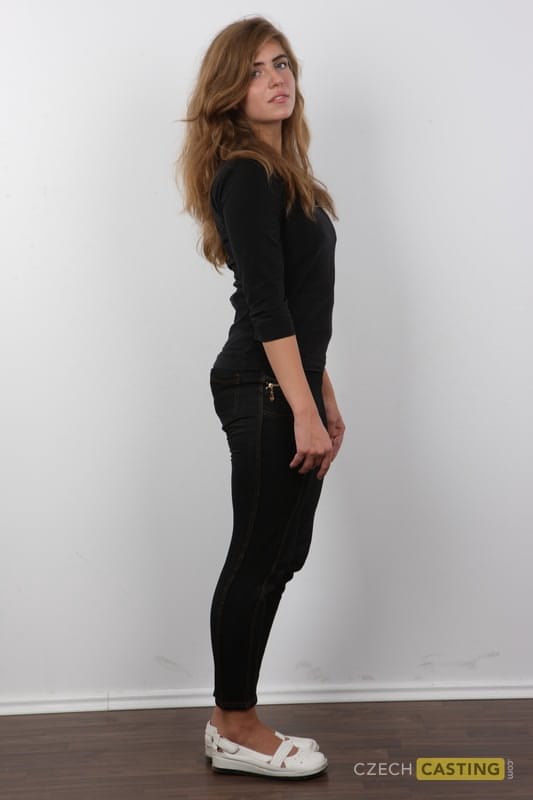 Flexible girl slips off her clothes and shoes in order to stand naked