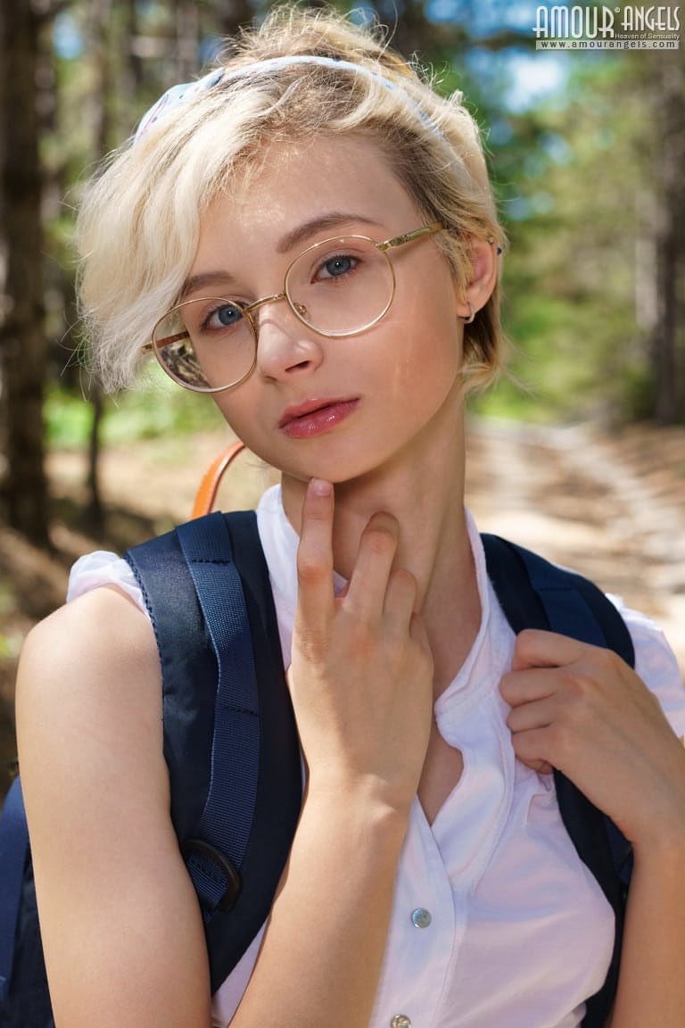 年轻女孩阿兹萨拉在树林中的土路上脱掉校服