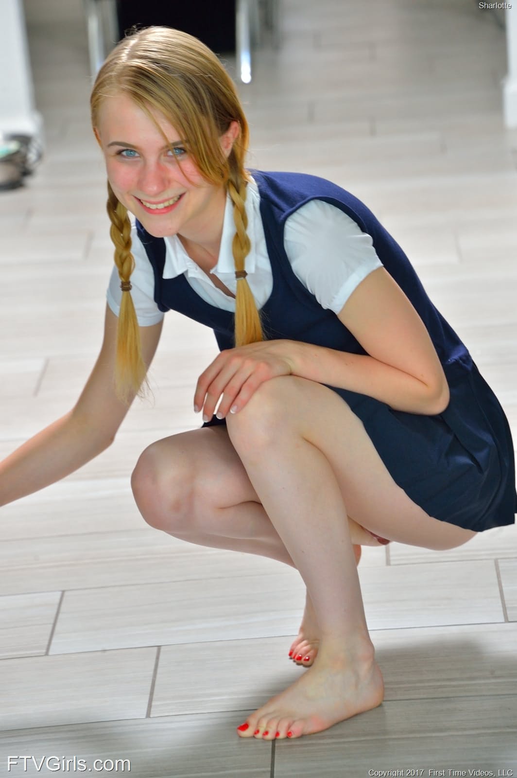 娇小的女学生Sharlotte穿着制服，弯腰在外面裸露上身。
