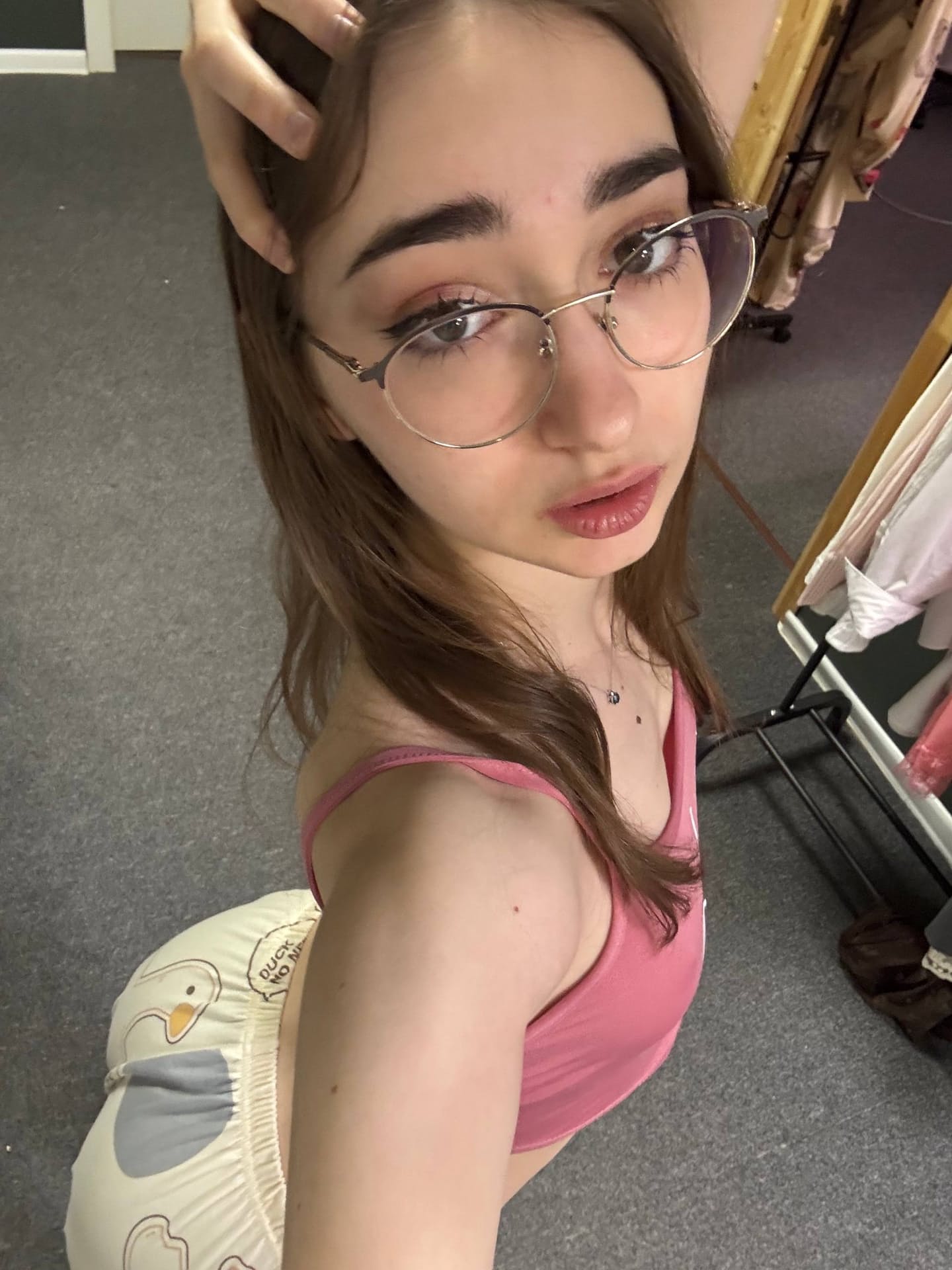 Thin teen with long hair takes selfies while wearing her glasses