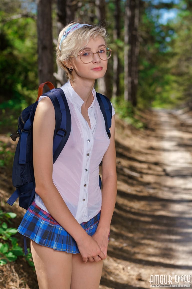 年轻女孩阿兹萨拉在树林中的土路上脱掉校服