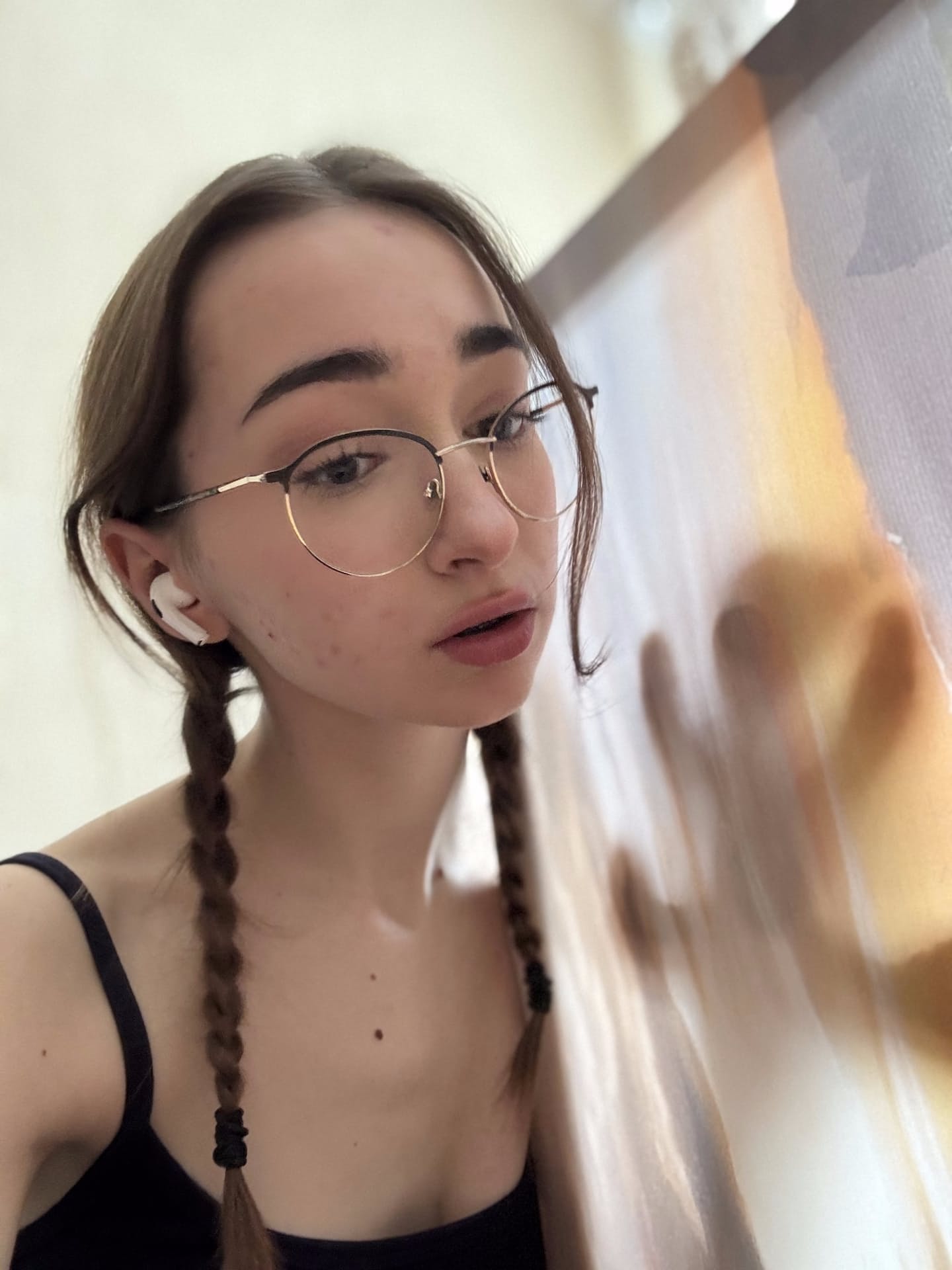 Sexy solo girl models lingerie in a mirror while wearing glasses