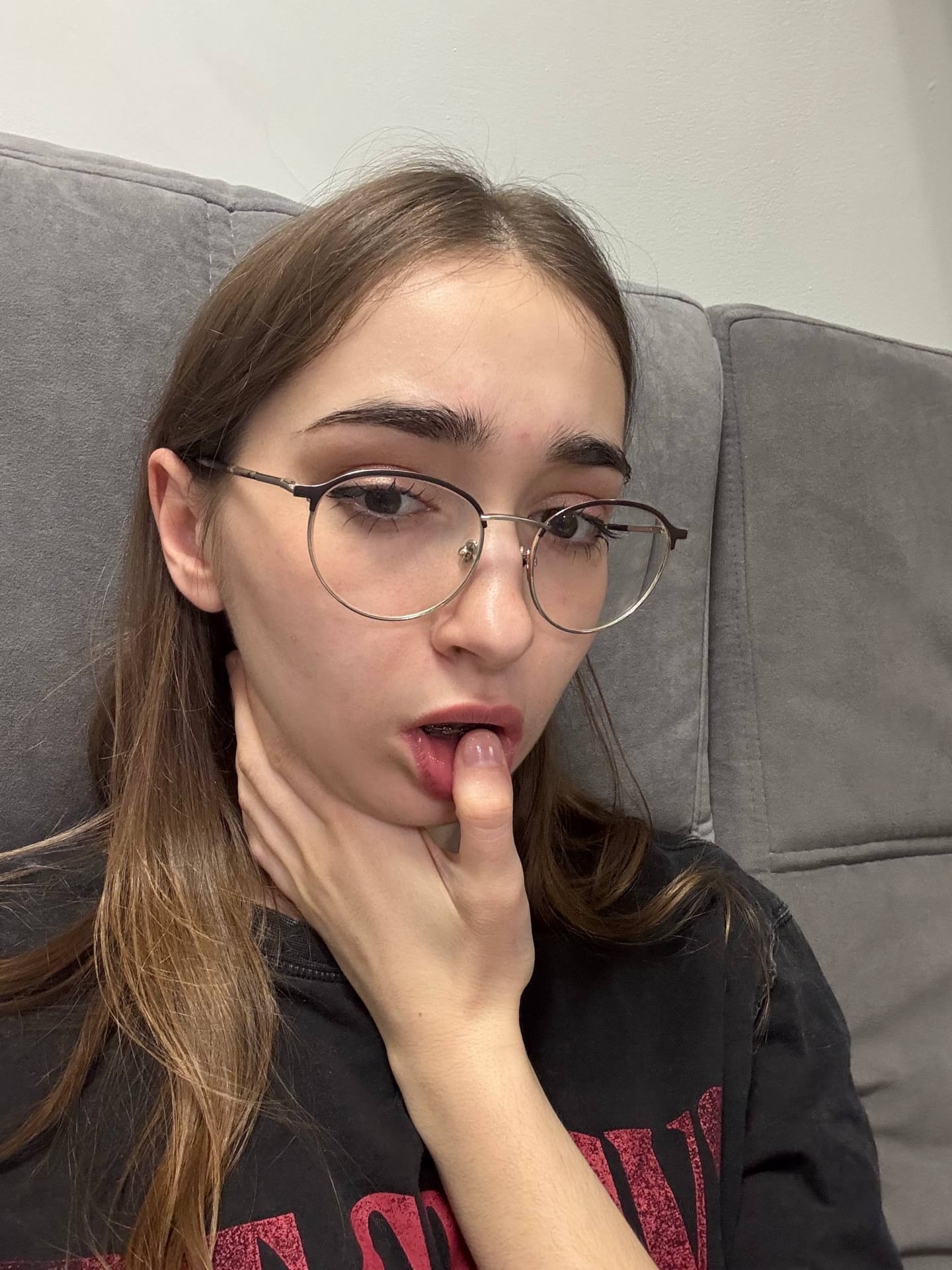 Thin teen with long hair takes selfies while wearing her glasses