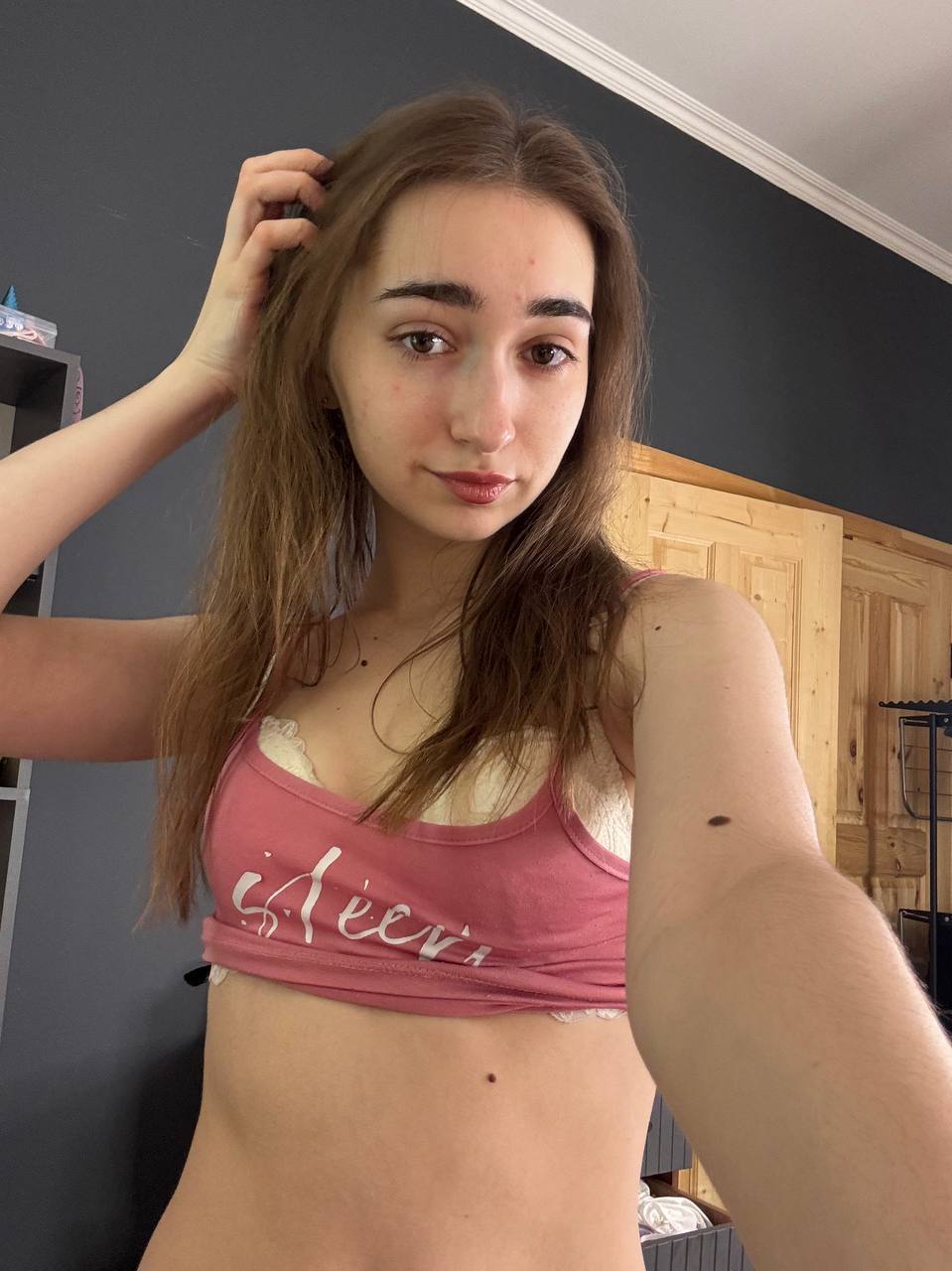Amateur girl with glasses and long hair takes selfies in revealing outfits