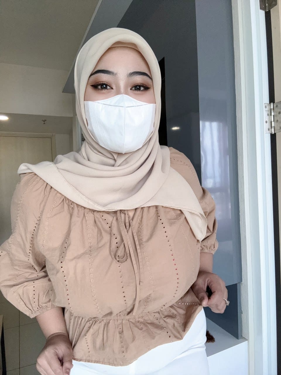 Solo girl with a mask over her mouth sports a hijab while exposing herself
