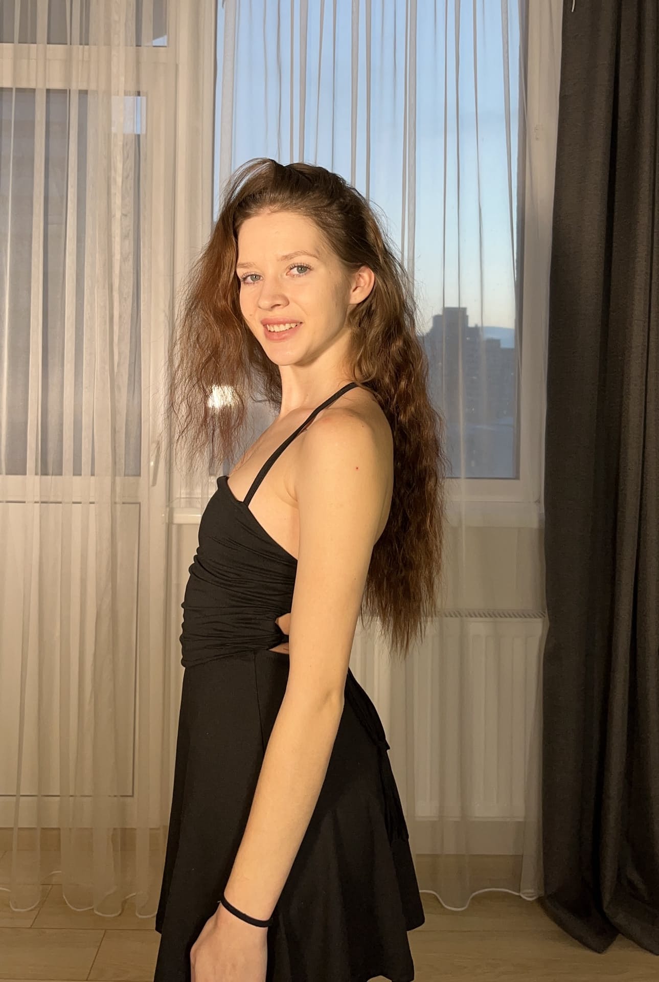 一位长发年轻美女身着黑色连衣裙，为个人写真摆出各种姿势