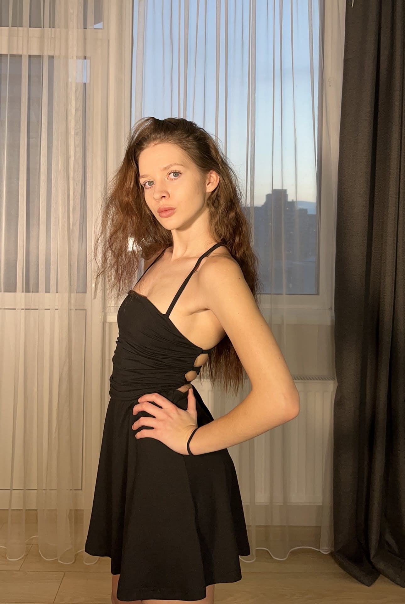 一位长发年轻美女身着黑色连衣裙，为个人写真摆出各种姿势