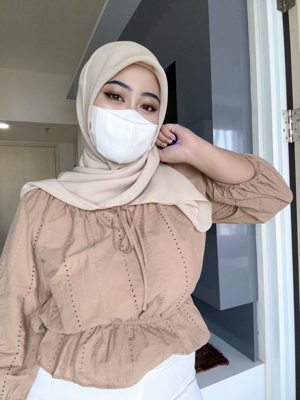 Solo girl with a mask over her mouth sports a hijab while exposing herself