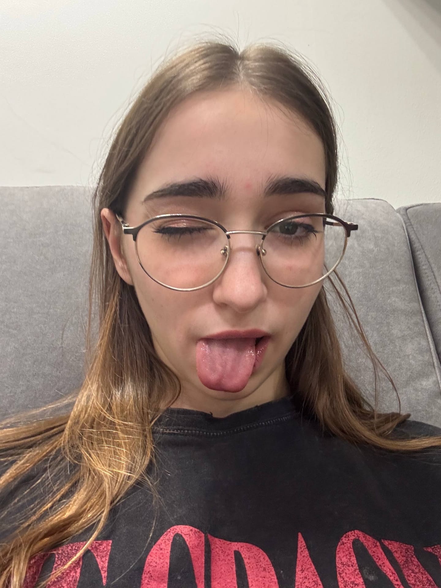 Thin teen with long hair takes selfies while wearing her glasses