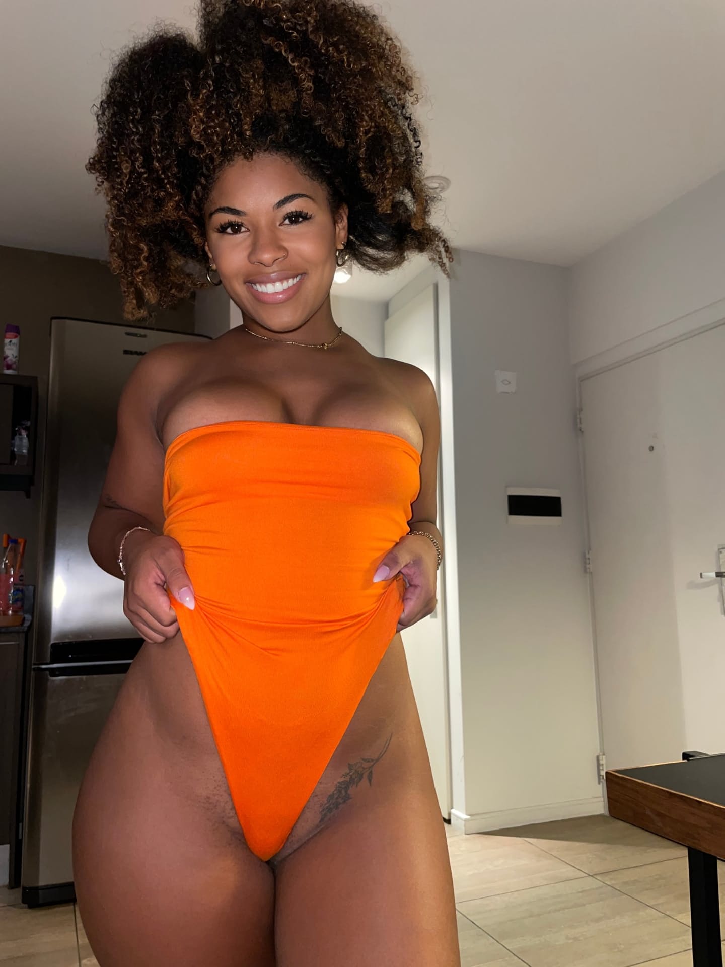 Ebony solo girl with a full head of curly hair models a lot of outfits