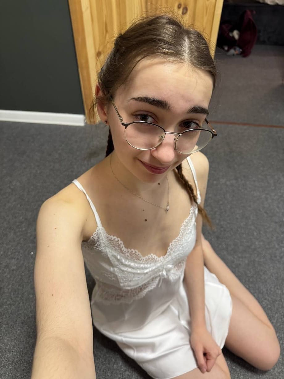 Thin teen with long hair takes selfies while wearing her glasses